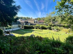 a large grassy yard with a building in the background at Bowlish House in Shepton Mallet