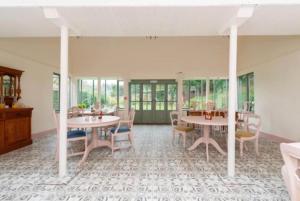 a dining room with tables and chairs and windows at Bowlish House in Shepton Mallet