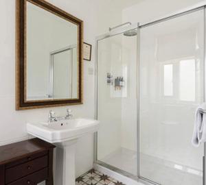 a bathroom with a sink and a glass shower at Bowlish House in Shepton Mallet