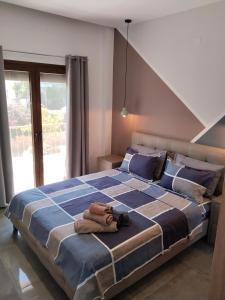 a bedroom with a large bed with a blue blanket at Theasis 2 in Neos Marmaras