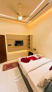 a bedroom with two beds and a flat screen tv at The Vacation Villa in Agra