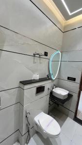 uma casa de banho com um WC e um espelho. em The Vacation Villa em Agra