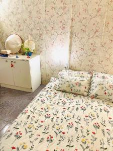 um quarto com uma cama com flores em Mika Homestay Simple & Cozy em Hanói