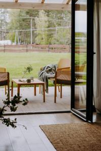 a screened in porch with a table and chairs at OSADA GRZYBOWSKI MŁYN apartamenty z dużym ogrodem KAISERÓWKA in Grzybowo