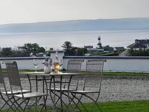 a table and chairs with wine glasses and a lighthouse at Grandma's Cottage in Greencastle