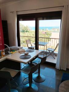 a dining room with a table and chairs and a balcony at Theasis 2 in Neos Marmaras