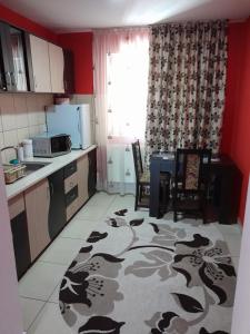eine Küche mit roten Wänden sowie einem Tisch und Stühlen in der Unterkunft Casa Matei in Sighetu Marmaţiei