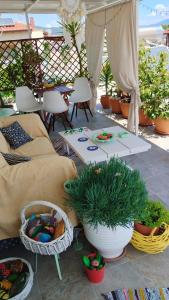 a patio with a couch and a table with plants at Suzy's nest room in Asprovalta