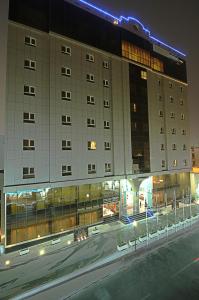 a large building on a city street at night at Corp Hotel Apartments and Spa in Doha