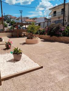 a patio with two potted plants and flowers at Theasis 2 in Neos Marmaras