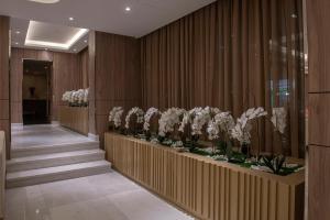 a hallway with stairs and white flowers on display at Corp Hotel Apartments and Spa in Doha