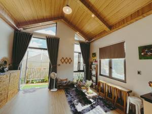 een woonkamer met houten plafonds en een groot raam bij Moon homestay.dalat in Da Lat