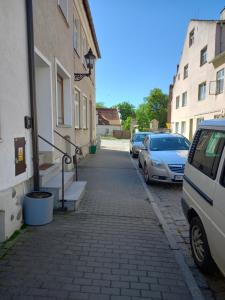 uma rua com carros estacionados ao lado de um edifício em Pokoje gościnne u Anka Reszel em Reszel