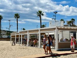 eine Gruppe von Menschen, die am Strand spazieren gehen in der Unterkunft SUN and BEACH LOVERS 12019 in La Pineda