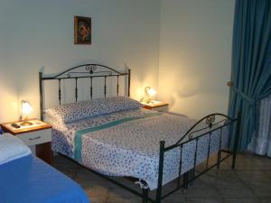 a bedroom with a bed and two lamps on tables at Le Tre Rose di Maria in Noto