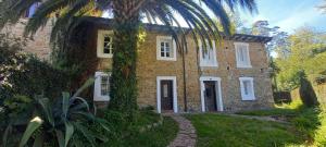 una casa de ladrillo con una palmera delante de ella en Posada -Meson la gándara 