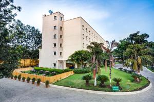 a building with palm trees in front of it at Radha Hometel in Bangalore