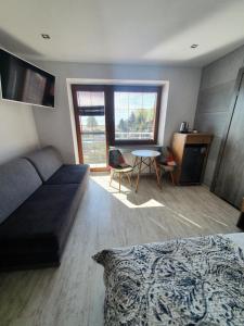 a living room with a couch and a table at Holiday House in Krynica Morska
