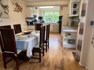 uma cozinha e sala de jantar com mesa e cadeiras em Cozy 3 bedroom bungalow in rural location em Ashwell