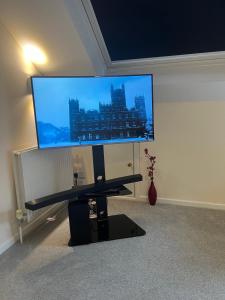 a large flat screen tv on a wall at Cozy 3 bedroom bungalow in rural location in Ashwell
