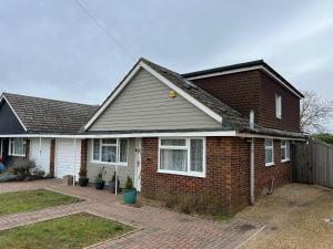 a brick house with a fence in front of it at Cozy 3 bedroom bungalow in rural location in Ashwell