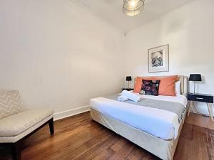 sypialnia z łóżkiem i krzesłem w obiekcie House Sharon w Melbourne