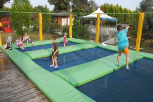 a group of children playing on a trampoline at Comfortable campsite-chalet G14 Tuscany at sea in Viareggio