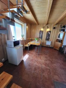 cocina y comedor con mesa en una cabaña en Namelis Rugilė, en Druskininkai