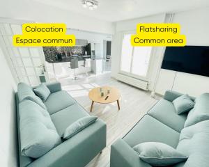 a living room with a blue couch and a table at Flatshare Colocation 4 close to Geneva in Saint-Genis-Pouilly