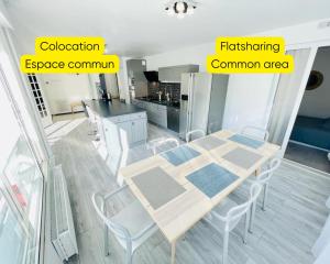a dining room with a table and chairs and a kitchen at Flatshare Colocation 4 close to Geneva in Saint-Genis-Pouilly