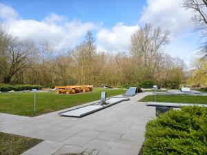 a park with benches and picnic tables in the grass at Vörde Stadtidyll in Bremervörde