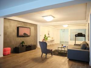 - un salon avec un canapé et une chaise dans l'établissement Spacieux appartement aux portes de Paris, parking gratuit, à Bagnolet