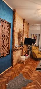uma sala de estar com pisos em madeira e uma televisão em Apartman Marijana em Novi Sad