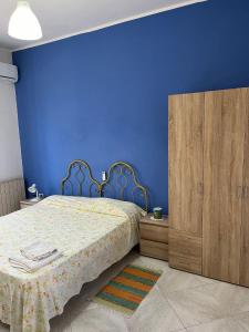 1 dormitorio azul con 1 cama y armario de madera en Ventura CasaVacanze en Oliveri