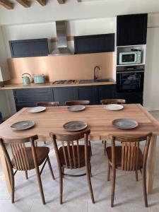 a wooden table and chairs in a kitchen at Maison bord de Loire in Saint-Clément-des-Levées
