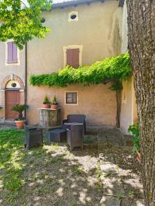 a building with a table and chairs in a yard at Casa Barattini in Zocchetta