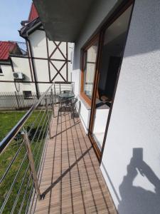 a view of a balcony with a table and a window at Holiday House in Krynica Morska