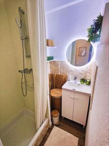 Un baño con lavabo y ducha con espejo. en Escapade Côtière au Grau du Roi, en Le Grau-du-Roi