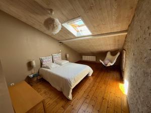 a bedroom with a bed and a window in a attic at Chambres de charme avec jardin et piscine in Coulonges-sur-lʼAutize