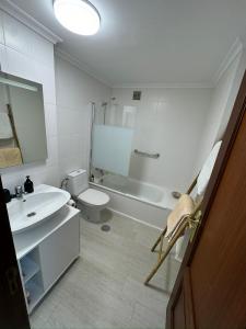 Baño blanco con lavabo y aseo en Apartamento a 5 minutos del casco histórico, en Viveiro