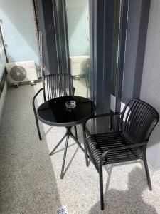 une table noire et deux chaises dans une pièce dans l'établissement MEB Apartments - Park Lake, à Cluj-Napoca