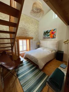 a bedroom with a large bed and a staircase at Chambres de charme avec jardin et piscine in Coulonges-sur-lʼAutize