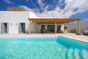 a pool in front of a house with a pergola at Morphe Villa in Aspro Chorio Paros
