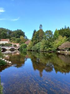 布朗托姆的住宿－Au Dolmen，一条有桥和树木的河流