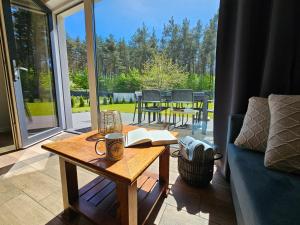a coffee table with a book and a cup on it at North Port in Kopalino