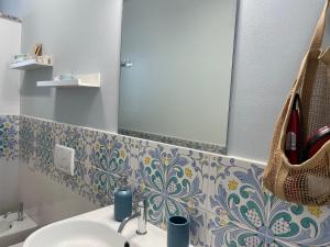 a bathroom with a sink and a mirror at Taormina Rooms Panoramic Apartments in Taormina