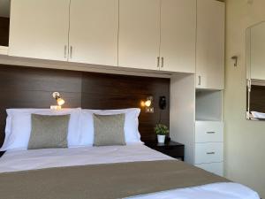 una camera da letto con un grande letto bianco con cuscini bianchi di Golf Hotel a Riccione