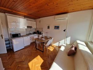 Apartment Nadija في راباك: مطبخ مع أريكة وطاولة في الغرفة