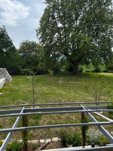 a metal fence with a tree in a field at Le Gast, Vaumeilh in Vaumeilh