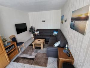 een woonkamer met een bank en een tafel bij Ferienwohnung Hidde in Ostseebad Koserow +12 foto's